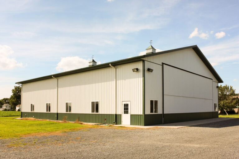 large implement shed with wide doorway and tan siding