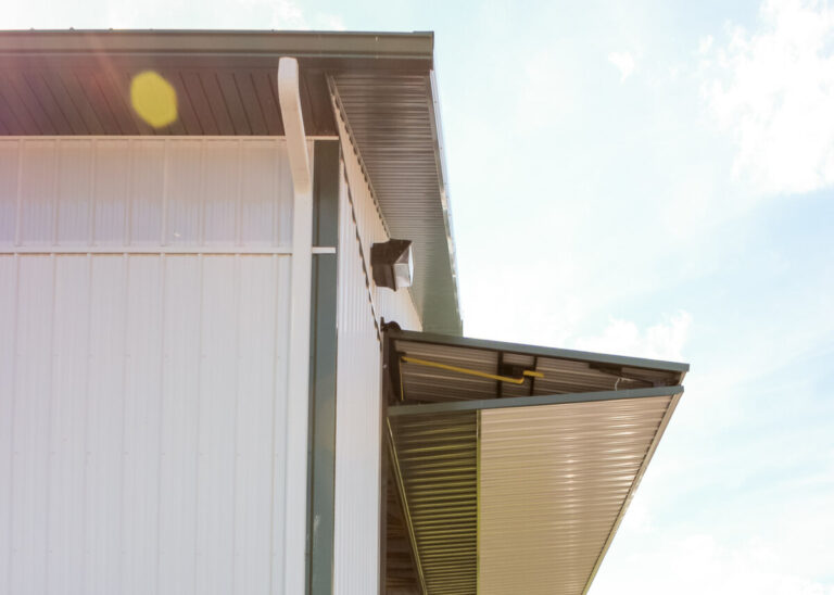 large implement shed with wide doorway and white siding