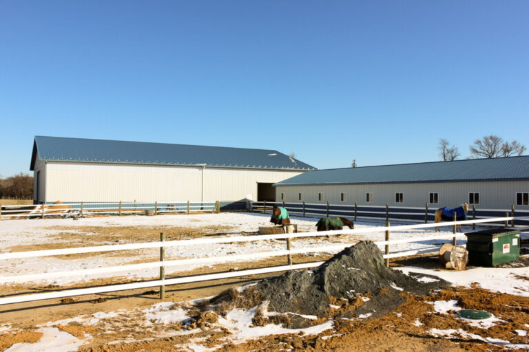 Pasture with a horse barn in the background