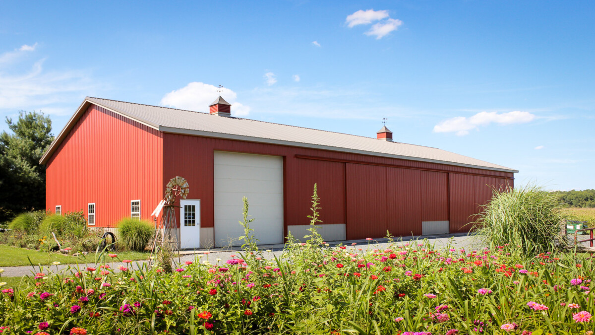 large implement shed with red siding built by byler builders